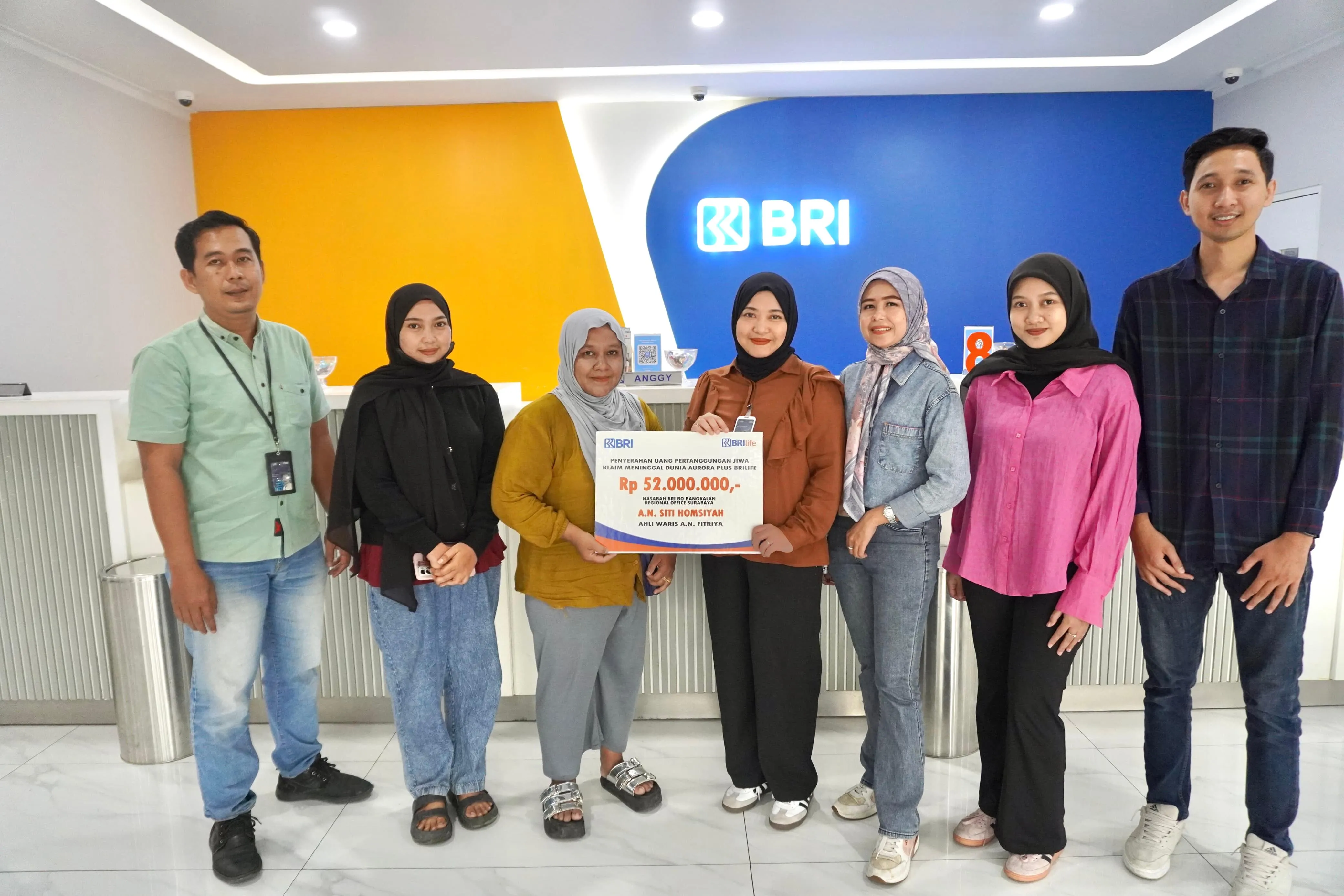Fitriya, ahli waris salah satu nasabah Bank BRI Bangkalan saat menerima klaim asuransi Aurora Plus dari Kepala BRI Bangkalan (Dok. Istimewa)