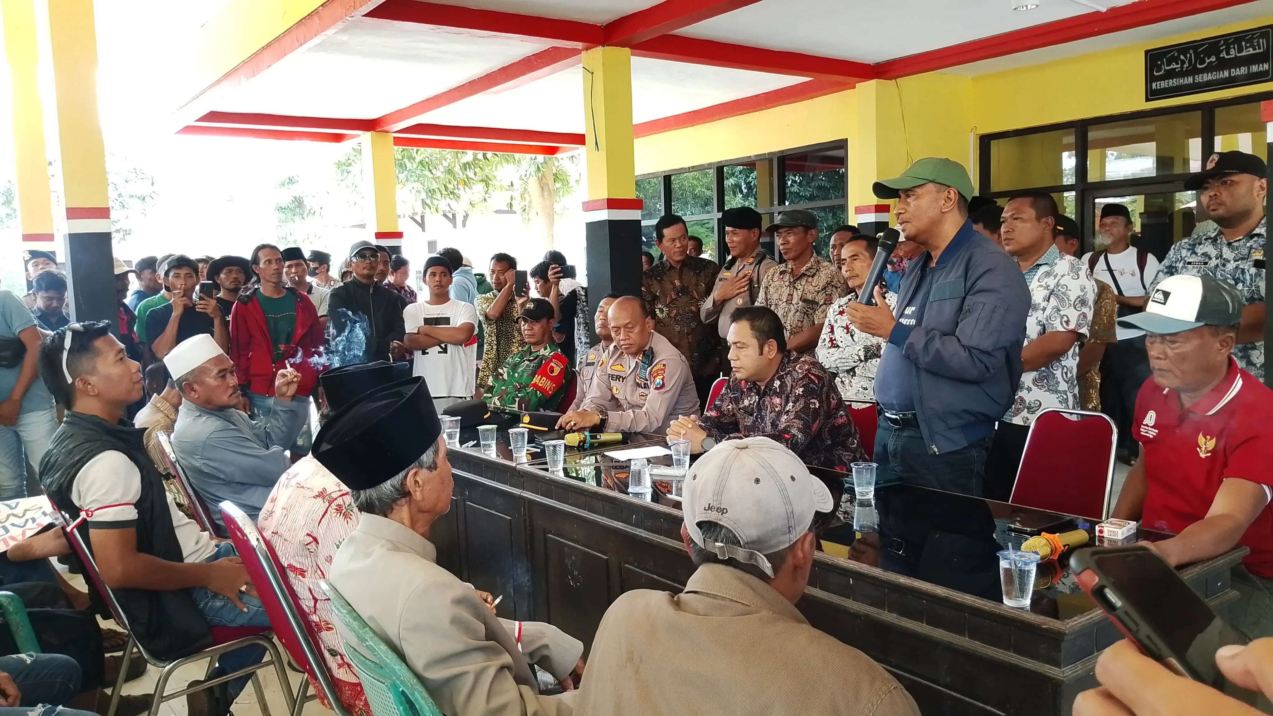 Anggota DPRD Bangkalan dari Kecamatan Kwanyar, Sonhaji, sedang memberikan tanggapan terhadap aspirasi ratusan masyarakat desa Pesanggrahan Kwanyar (Foto/Syah)