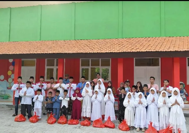 Kaconk Mahfud Institute (KMI) bersama Kepala Desa Kebun, Abdul Ghoni, berfoto bersama anak-anak yatim usai penyerahan santunan dalam kegiatan berbagi berkah Ramadan di Desa Kebun, Kabupaten Bangkalan. Kegiatan ini diharapkan dapat memberikan manfaat sekaligus memotivasi anak-anak yatim untuk terus semangat meraih masa depan (Foto/Syah)