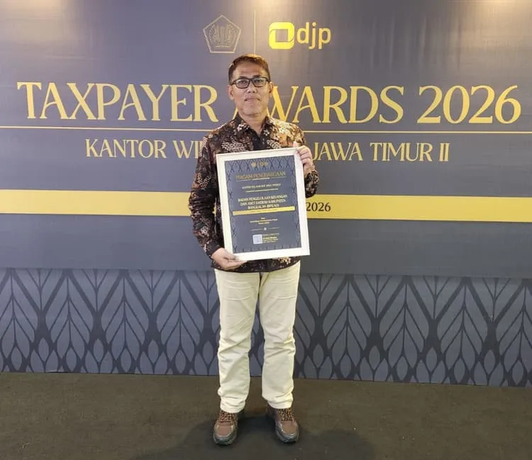 Kepala BPKAD Bangkalan, Ahmad Hafid, menunjukkan penghargaan Taxpayer Award yang diraih Pemkab Bangkalan sebagai bukti komitmen dalam kepatuhan pajak (Foto/Istimewa)